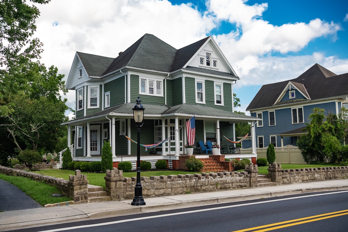 classic American house colonial style. Veranda with columns and flag at entrance.