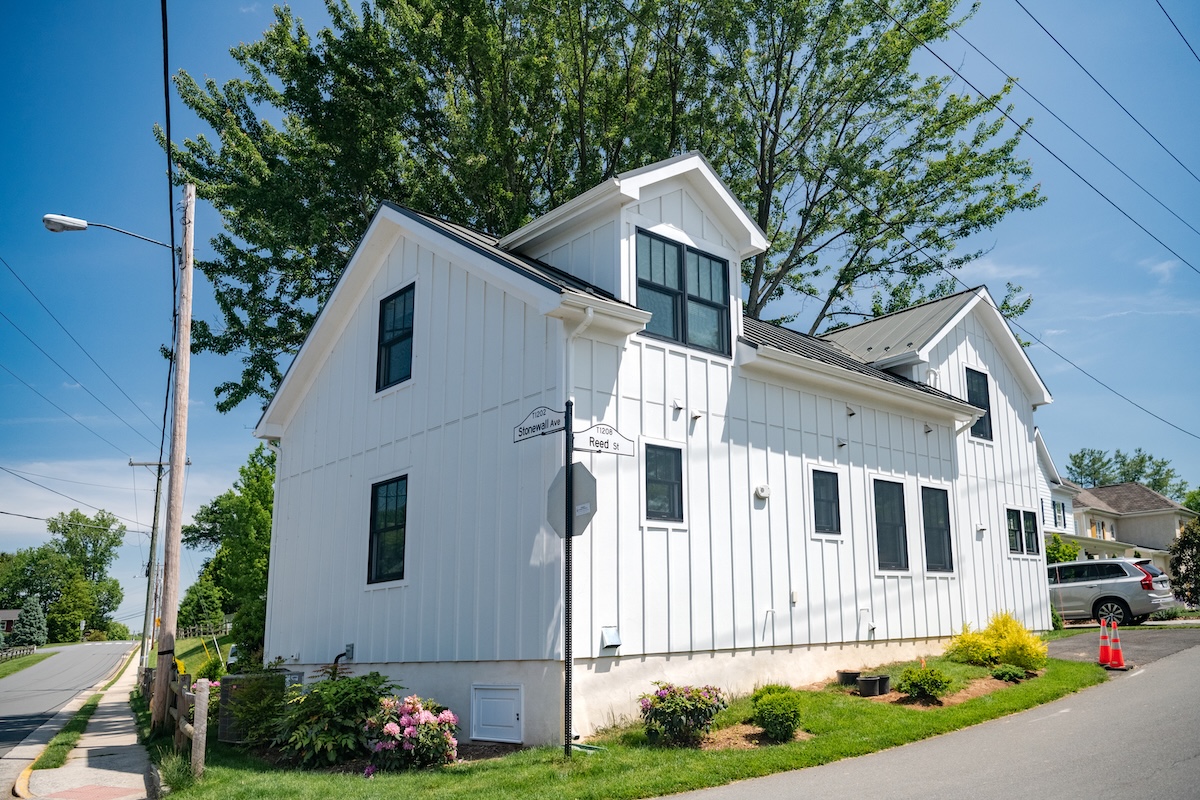 small two-story residential building with white siding. mowed lawn and manicured frontyard.