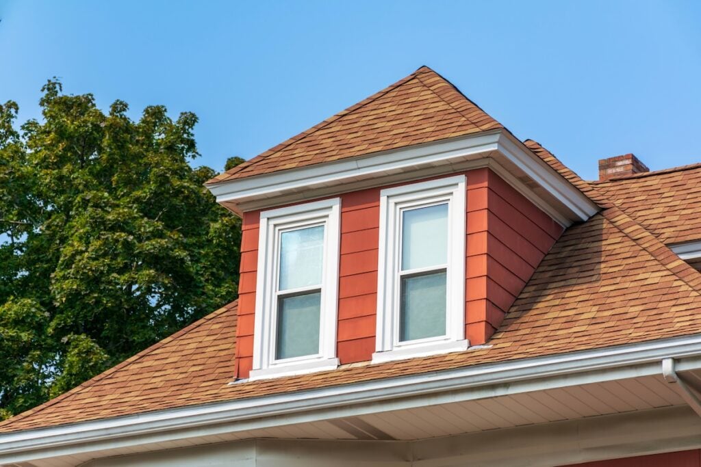 Hip dormer window on the sloped roof of a family house