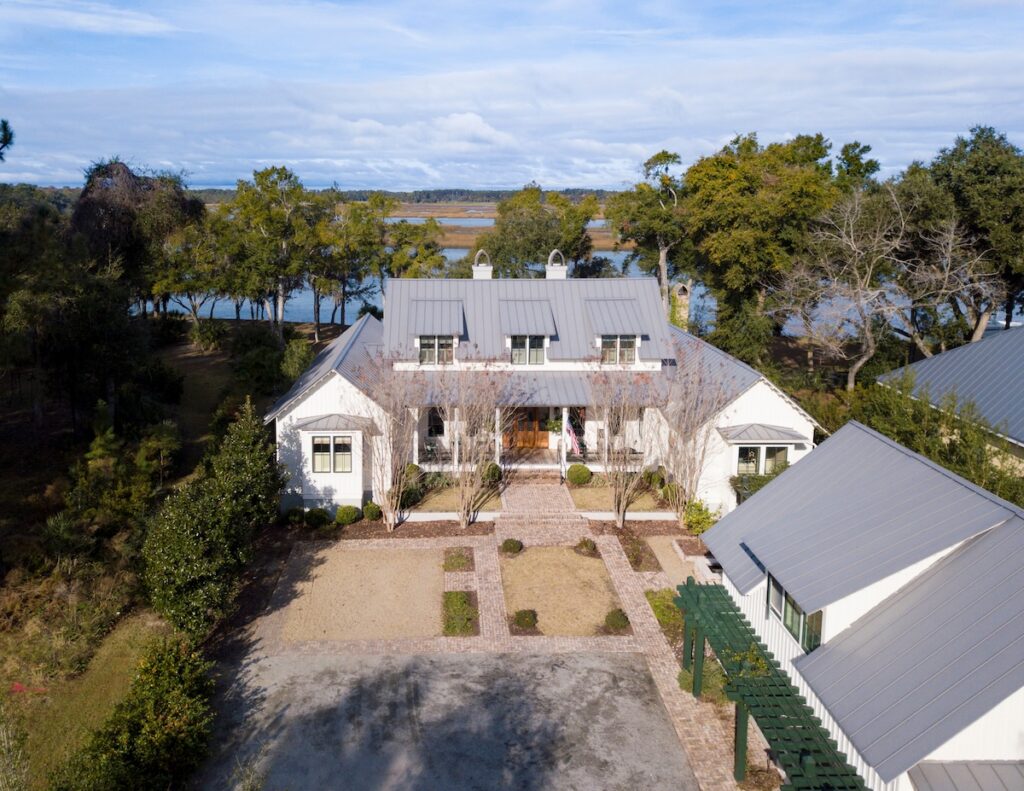 Low aerial view of beautiful, large, waterfront property on river with a new metal roof